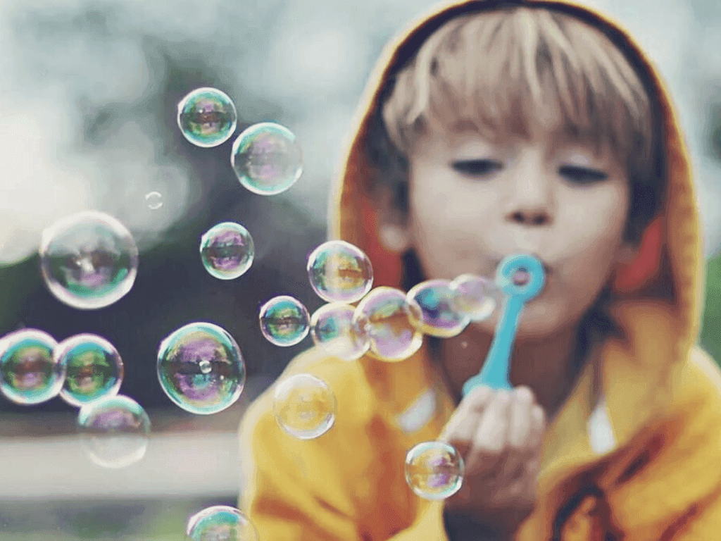 Enfant jouant avec des bulles de savon